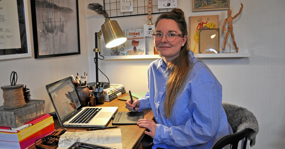 En brunhårig kvinna i blå skjorta i ett hemmakontor med konstnärsmaterial | © Foto: Adrian Norström