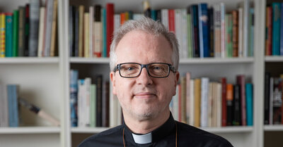 En man i prästskjorta framför en bokhylla | © Foto: Marcus Gustafsson