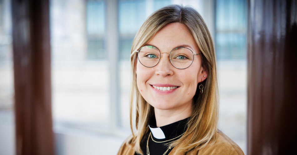En glad kvinna med prästskjorta och runda glasögon. | © Foto: Mikael M Johansson
