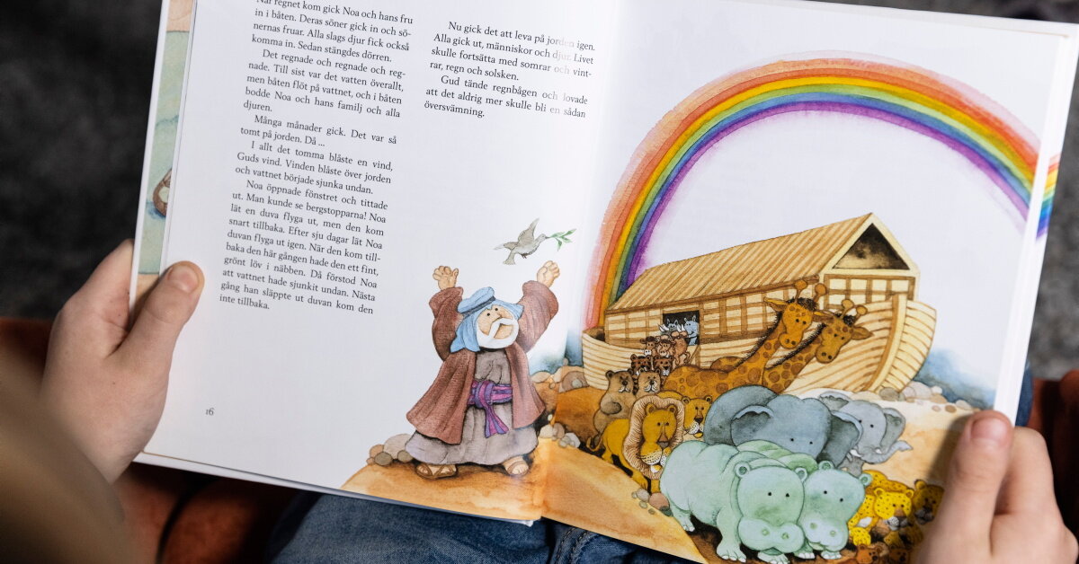 Barn läser ur barnens bibel, på uppslaget visas berättelsen om Noas ark