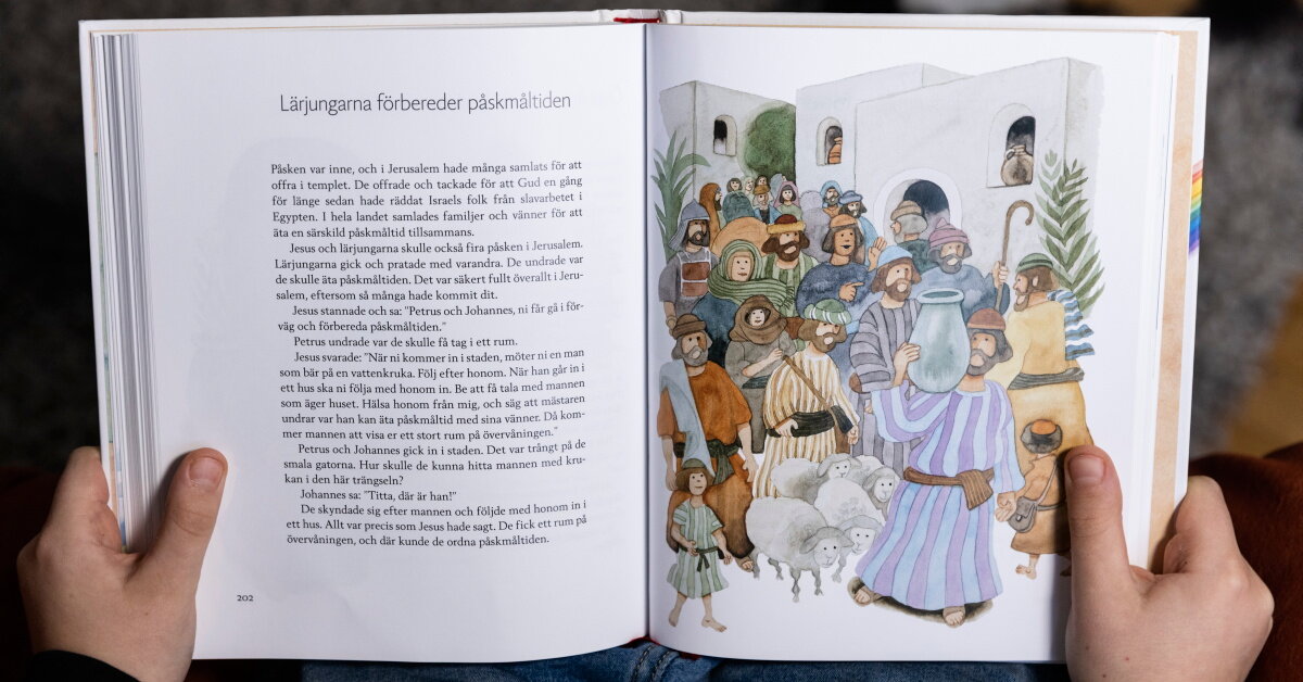 Barn läser ur barnens bibel, på uppslaget visas berättelsen om hur Lärjungarna förbereder påskmåltiden.