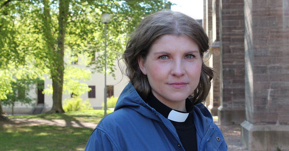 En mörkhårig leende kvinna i svart skjorta och prästkrage | © Foto: Emmelie Simmons