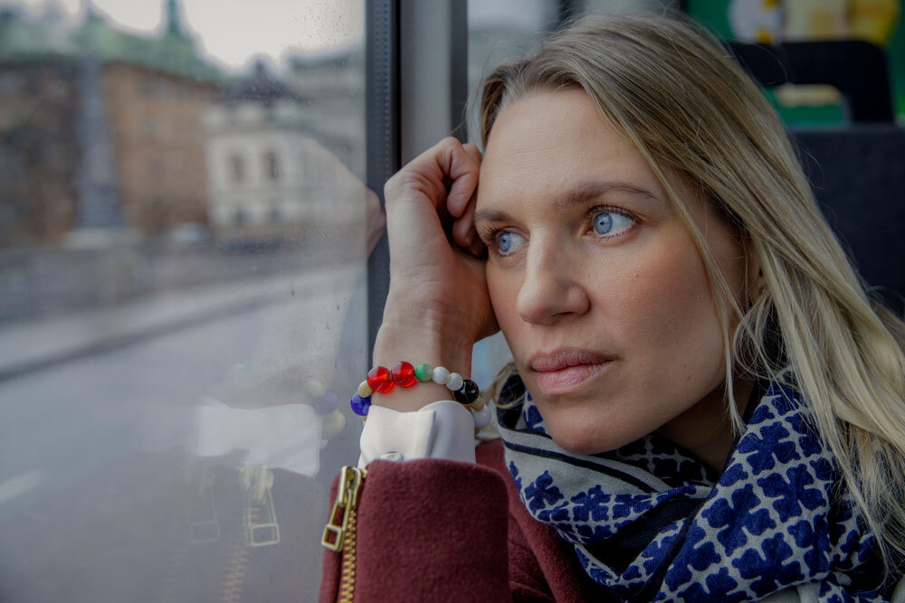 Kvinna som bör frälsarkransen sitter på bussen med huvudet lutat emot fönstret. | © Photo: Mikael M Johansson