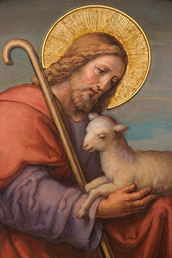 Målning av Jesus hållandes i ett vitt lamm med en gloria och herdekäpp lutad emot axeln.