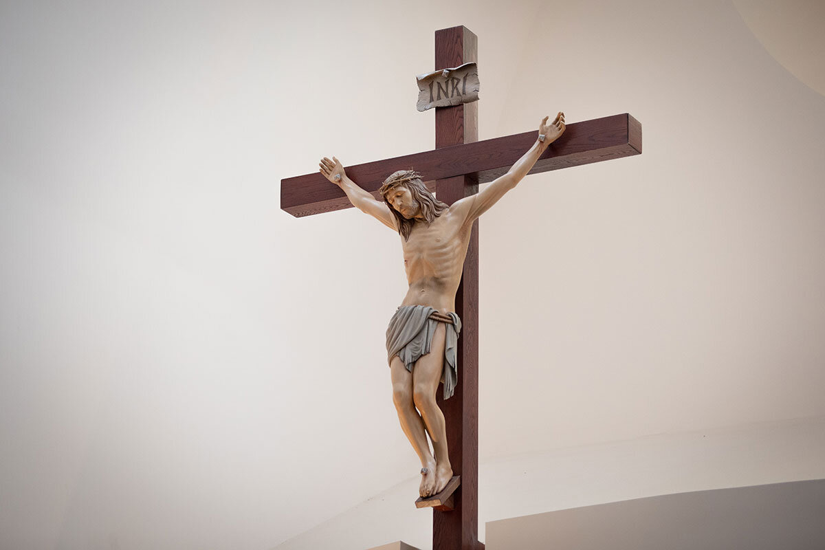 Träkors med Jesus korsfäst på mot en vit bakgrund.