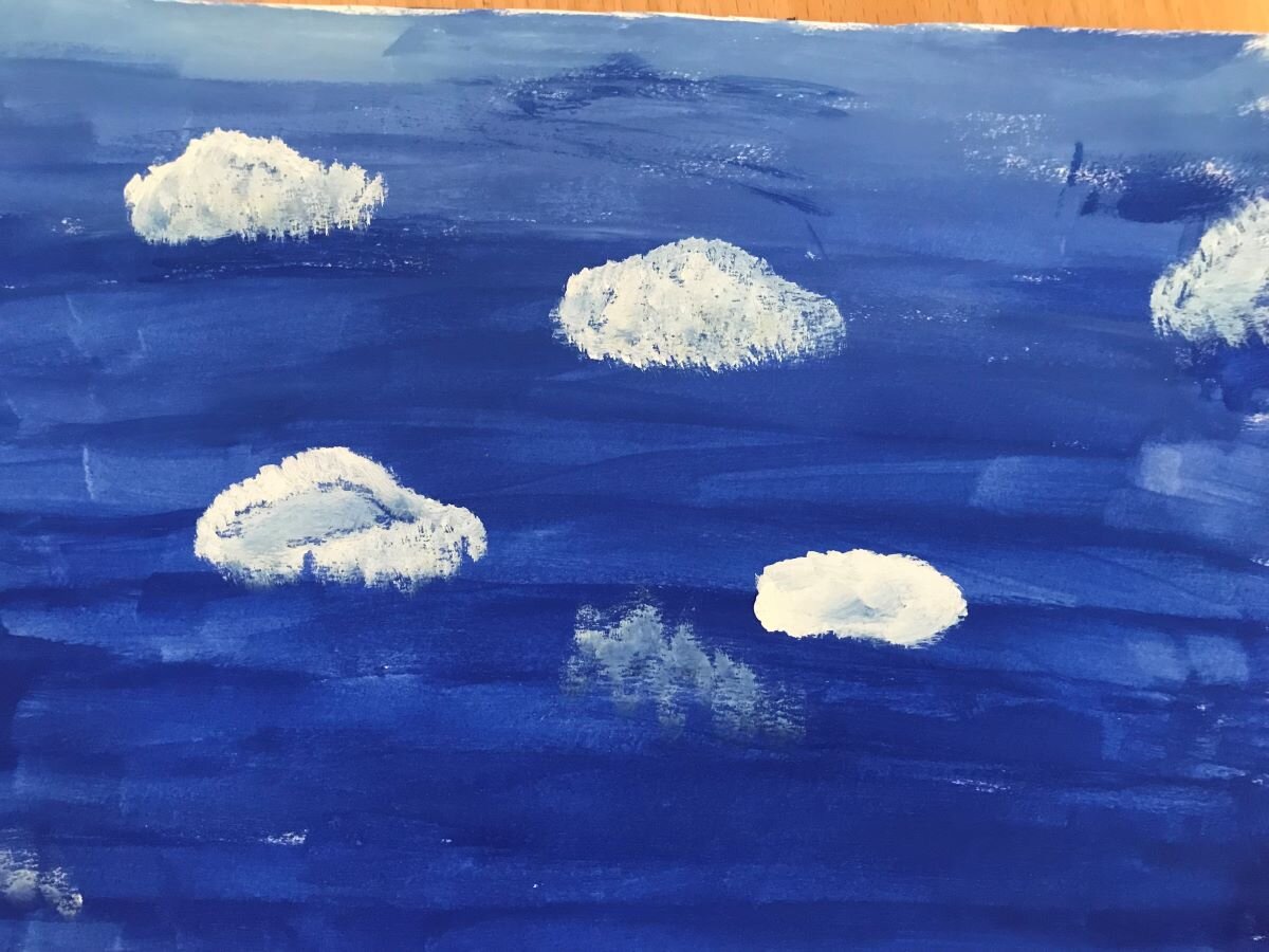 En teckning som visar en blå himmel med flera små vita molntussar.