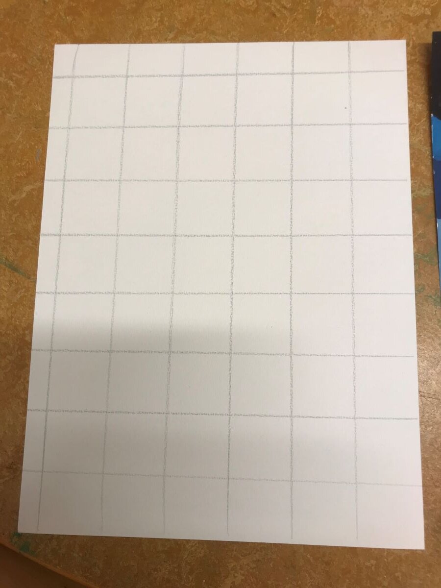 Ett rutnät skissat på ett vitt papper.