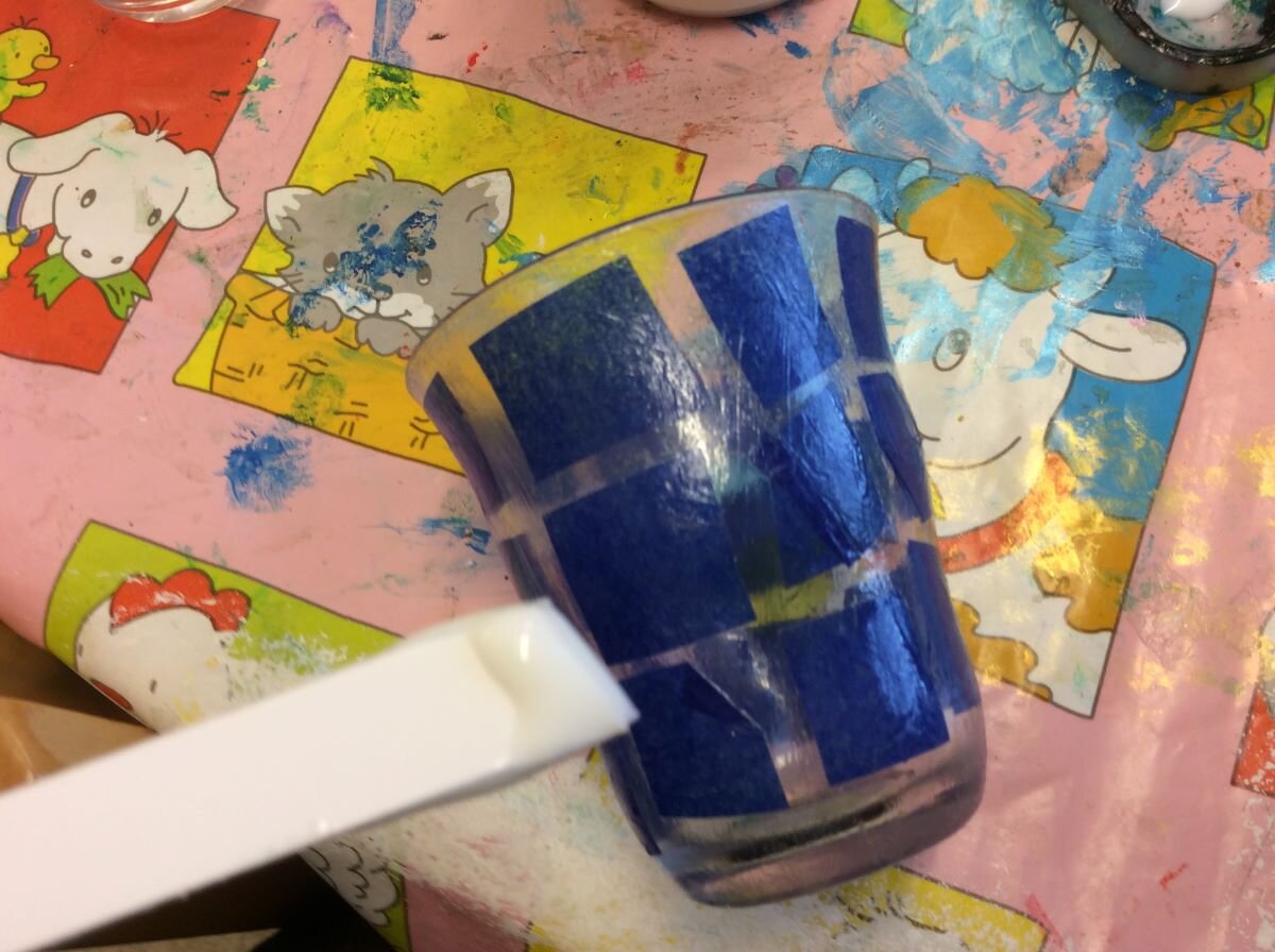 Ett liggande glas täckt av fastlimmade pappersbitar.