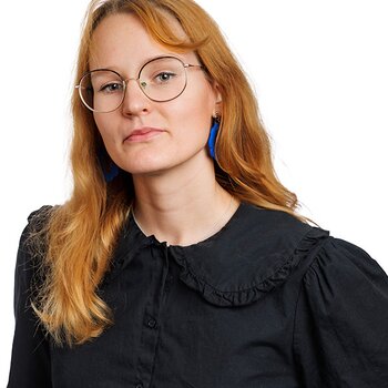 En kvinna med rött hår och glasögon